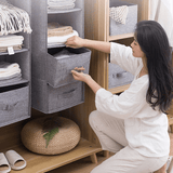 woman removing drawer from gray hanging wardrobe organizer