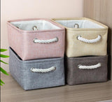 four cotton linen storage baskets in pink, beige, gray, and brown