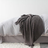smokey gray knitted sofa throw used as light blanket in bedroom