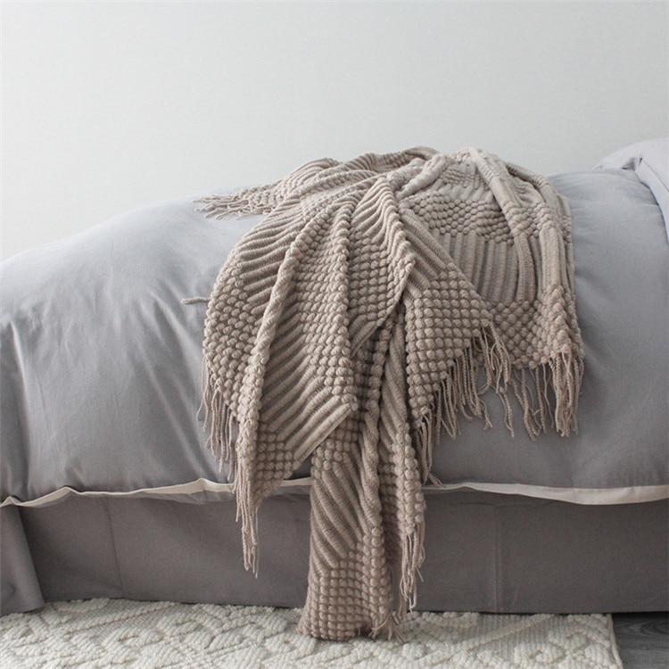 khaki knitted sofa throw used as blanket in bedroom