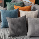 quilted velvet throw pillows in six different colors on sofa