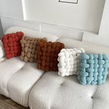 various colors of coal and cove knotted plush cushions on living room sofa