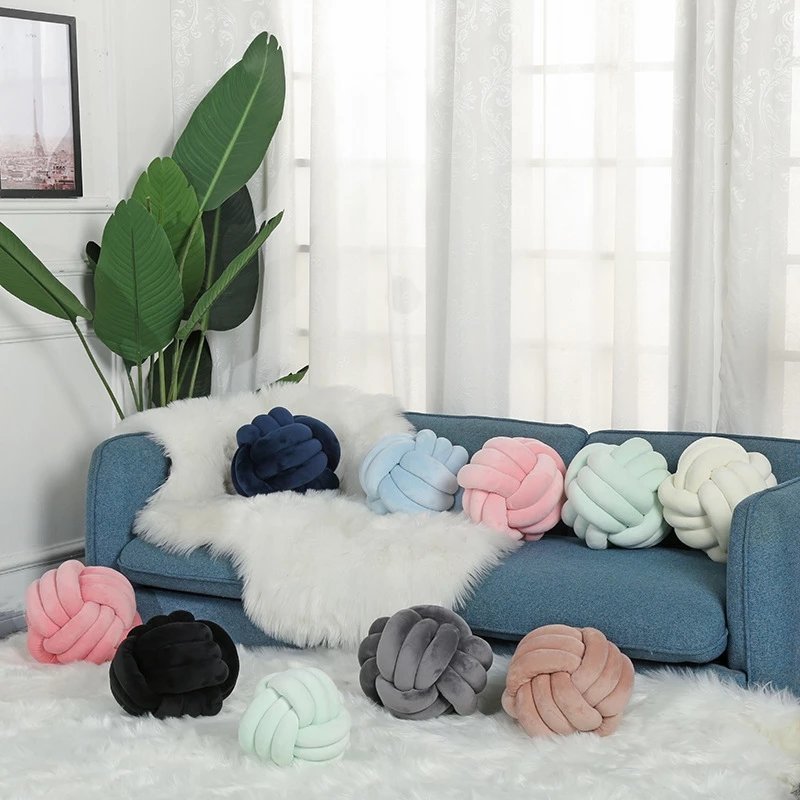 knotted throw pillows in living room on sofa and rug