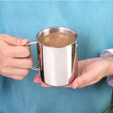 hand holding warm coffee in stainless steel mug