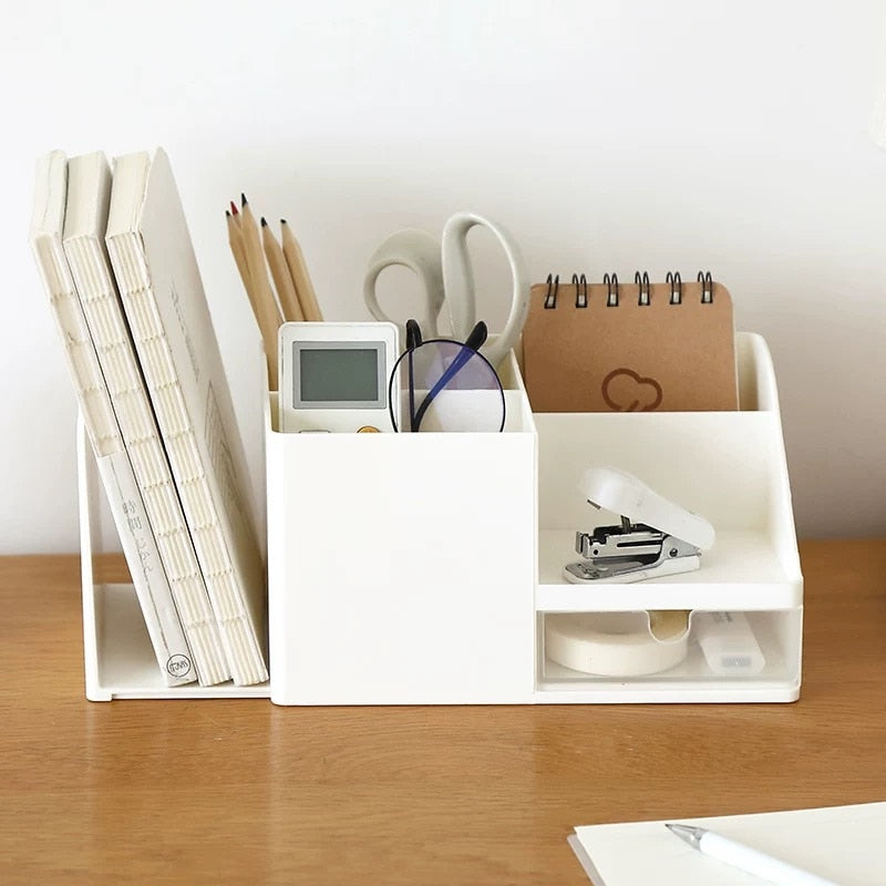 beige desktop organizer holding stationery items, notebooks, and glasses on wooden desk