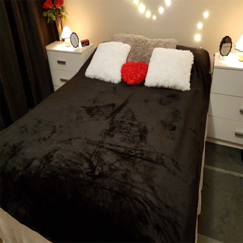 black coral fleece blanket used to make bed with pillows neatly placed