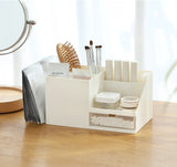 beige desktop organizer holding makeup supplies, brushes, and cotton swabs on wooden desk